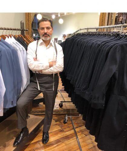 Robinson standing with racks of suits