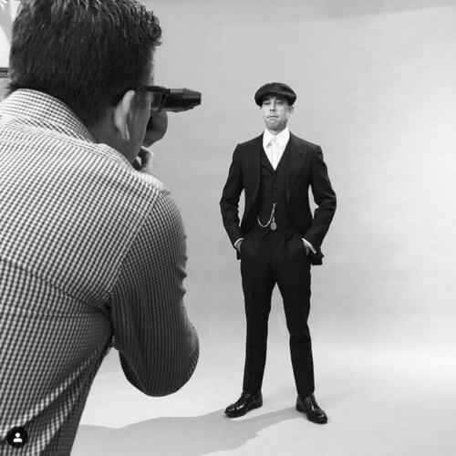 Photographer taking a photo of a model wearing a three piece suit