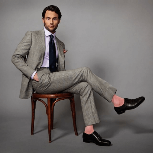 Penn Badgley modeling a light grey suit