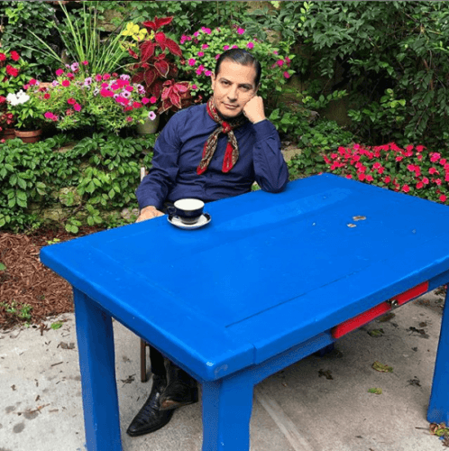 Robinson sitting outside enjoying a hot beverage