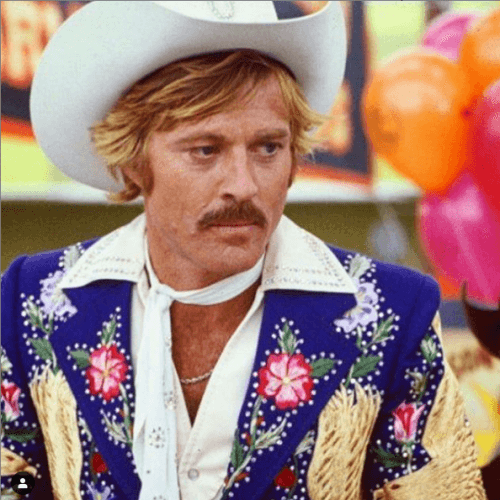 Man in a cowboy hat and colorful suit jacket