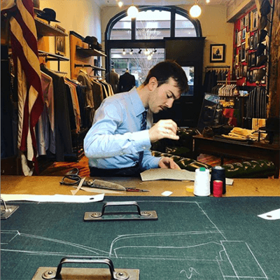 Tailor stitching a piece of fabric