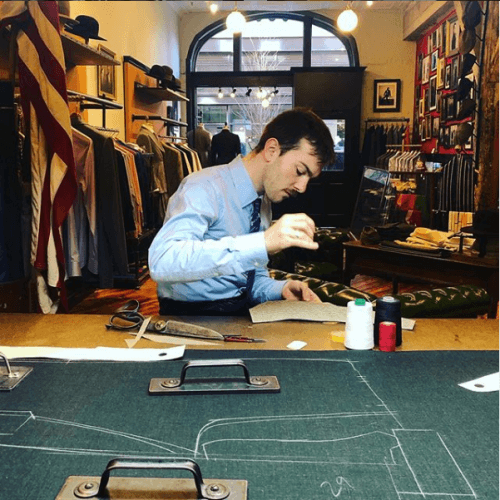 Tailor stitching a piece of fabric