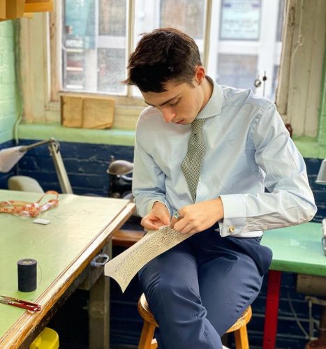 Tailor sewing a piece of fabric