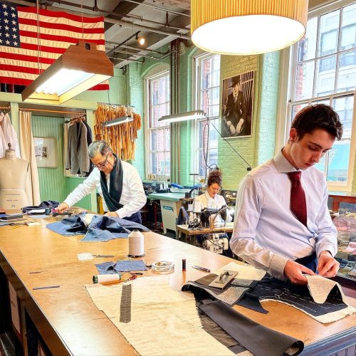 Tailors cutting fabric for patterns